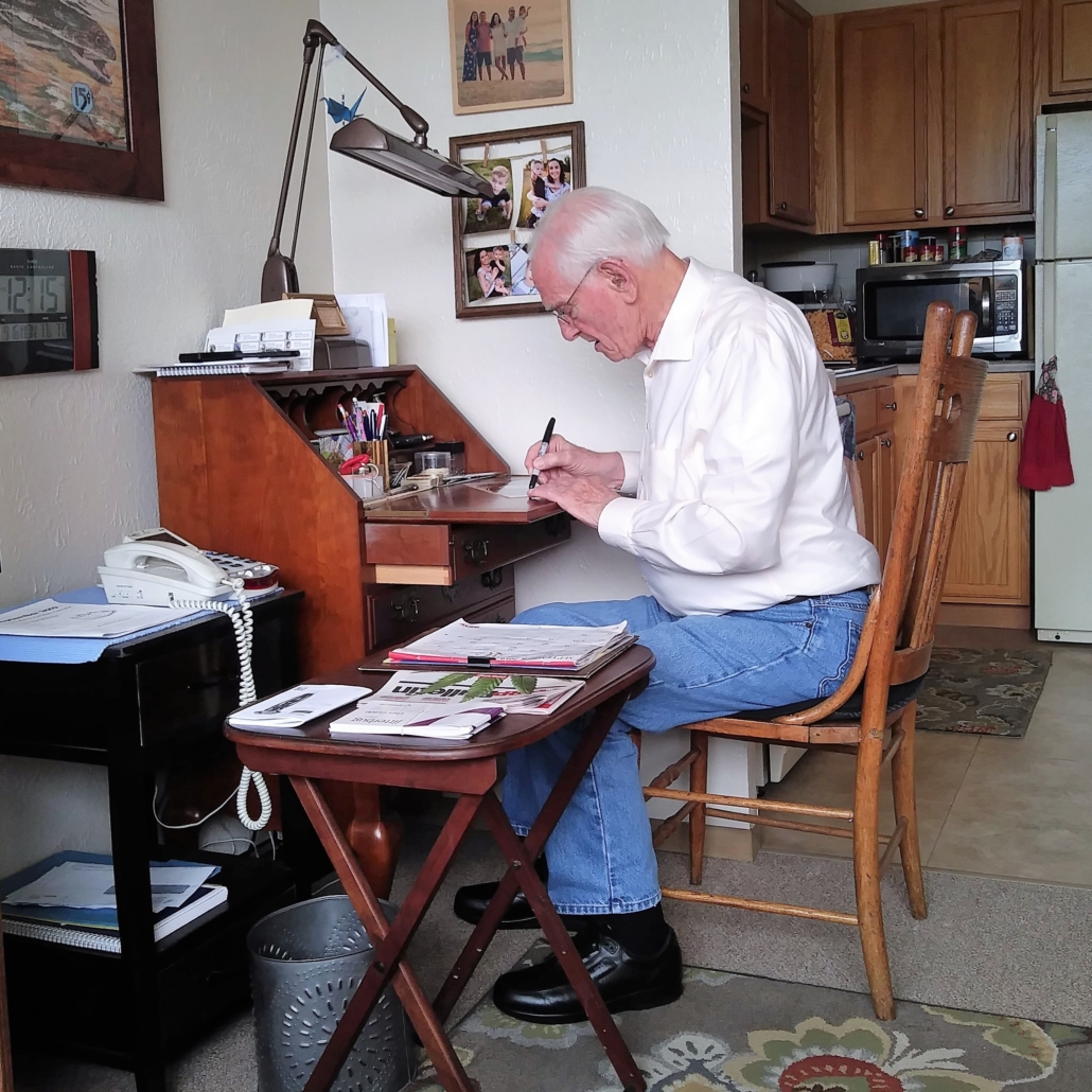 This photo shows Homer Finley at his writing desk with a pen. 