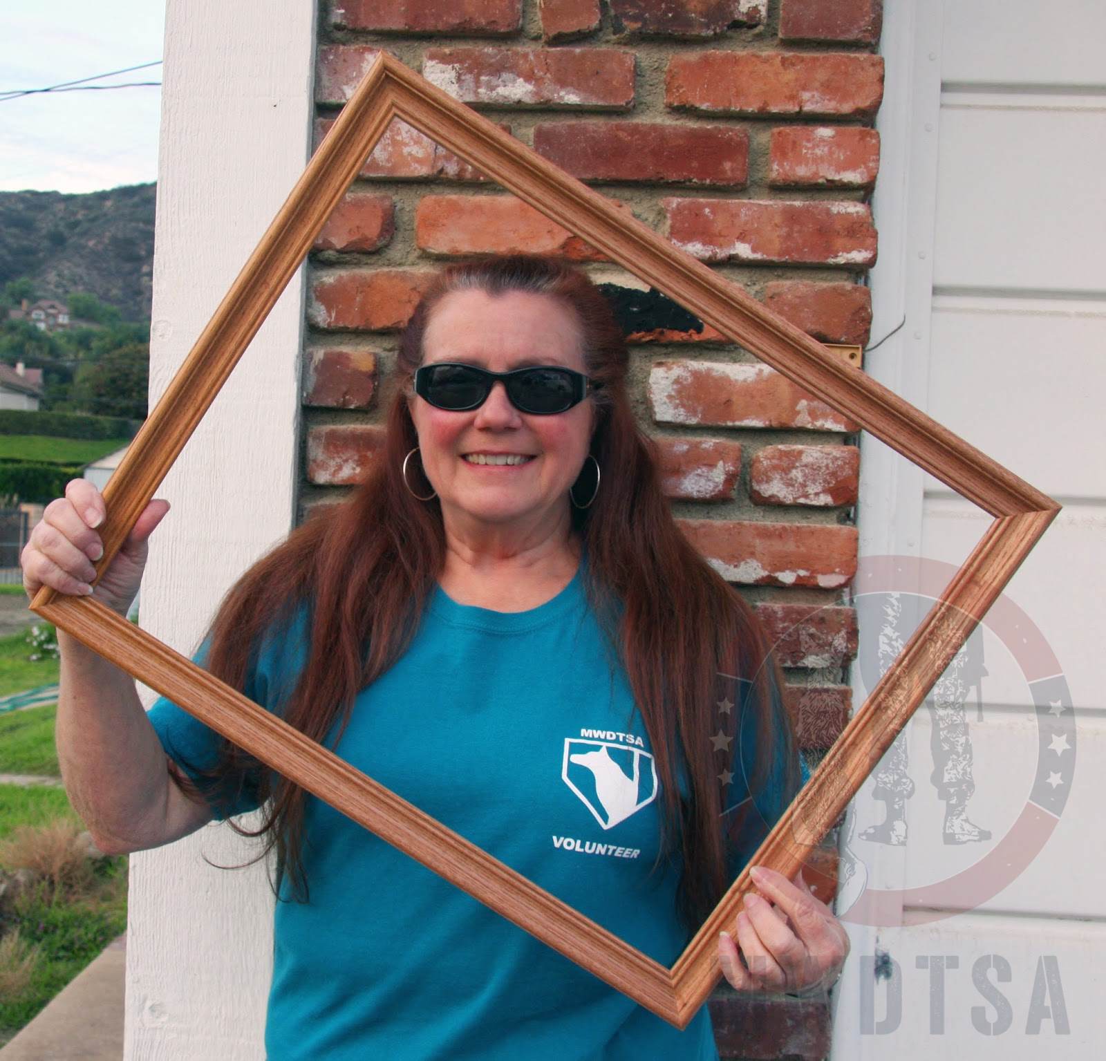 Jan Slotar holding up a picture frame so you can picture yourself as a volunteer!