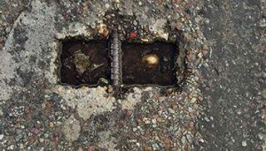 Durrance photographed the aging handle of a street sewer access lid. The image looks like a pair of square eyes, haunted with pain.