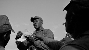 This image shows a soldier with a stack of envelopes, calling out recipients' names.