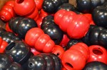 An assortment of red and black KONG toys