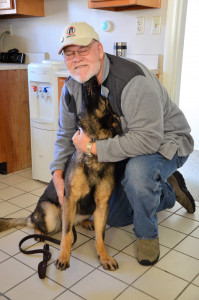 Photo shows MWDTSA volunteer Jerry Whitman receiving love from MWD Sindy.