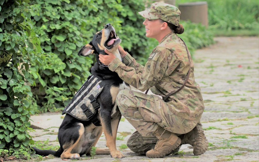 Tiffany Baker kneels with her service dog Buddy. K9s for Warriors paired Baker and Buddy, and this heart-warming photo shows the bond between them.