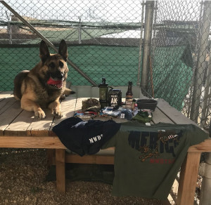 Photo of deployed military working dog next to care package contents from corporate sponsors.