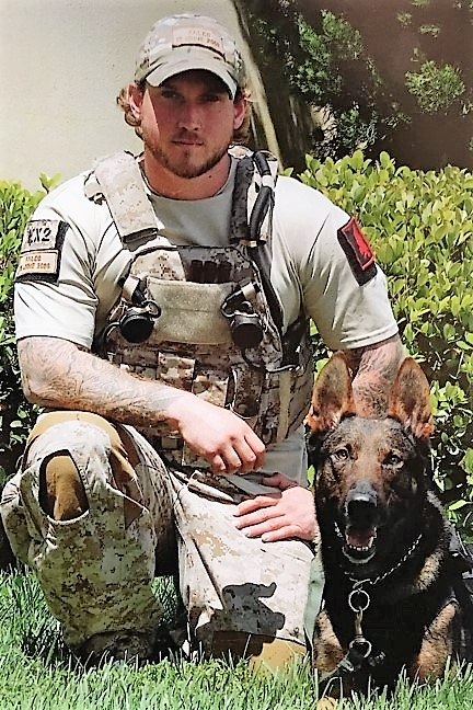 This photo shows Will Chesney in uniform, kneeling beside MWD Cairo.