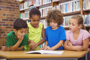 Four elementary school students collaborate on researching a military working dog as part of a 3rd- and 4th-grade lesson plan.