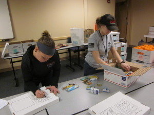 This photo shows two volunteers preparing for the packing event.