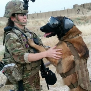 The photo on the Sponsors page shows a female service member, standing, with her MWD on his rear legs, paws on her shoulders. The MWD is wearing RexSpecs dog goggles.