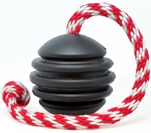 Here's a photo of the USA-K9 by Sodapup toy MWDTSA is collecting during Pepper's Donation Drop 2022. It's a sturdy black rubber ball with deep grooves for dental and mental stimulation, along with a slot for inserting treats. The red and white candy cane coloring of the attached rope adds a holiday feel. The rope allows this to be used as a tug toy or for fetch.